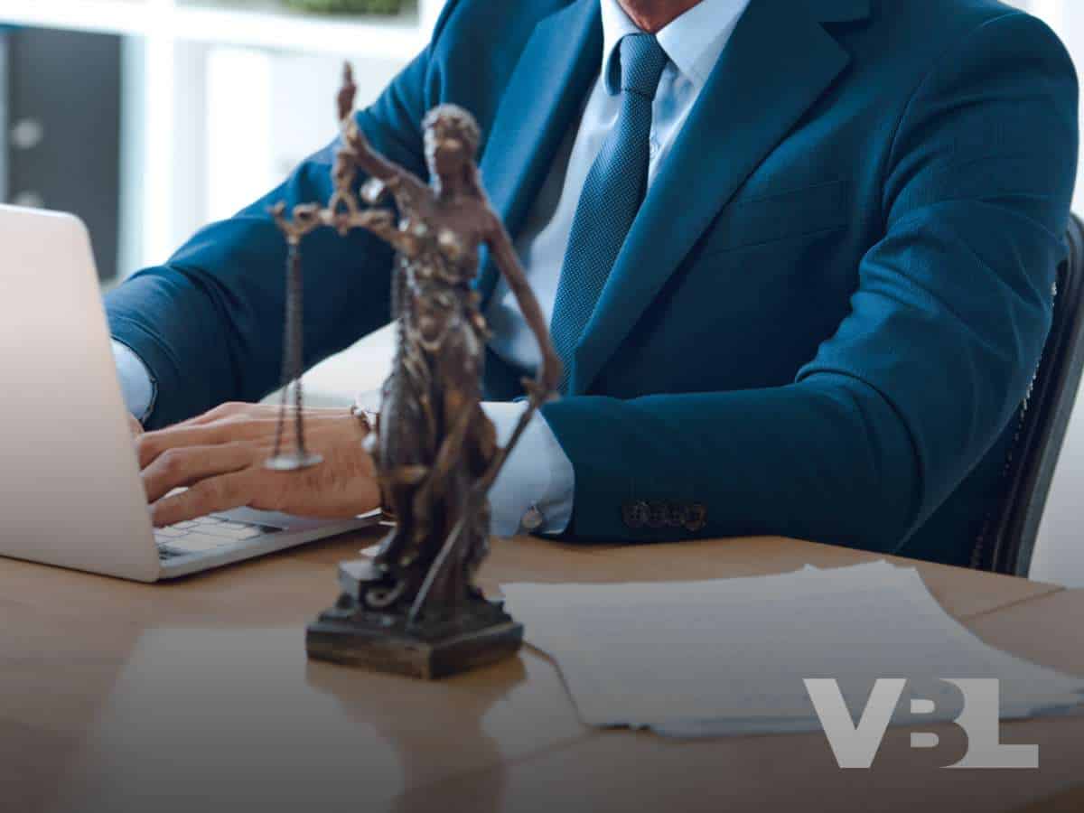 Attorney working on a laptop with a legal statue and papers related to Buffalo Bill's Resort & Casino closure