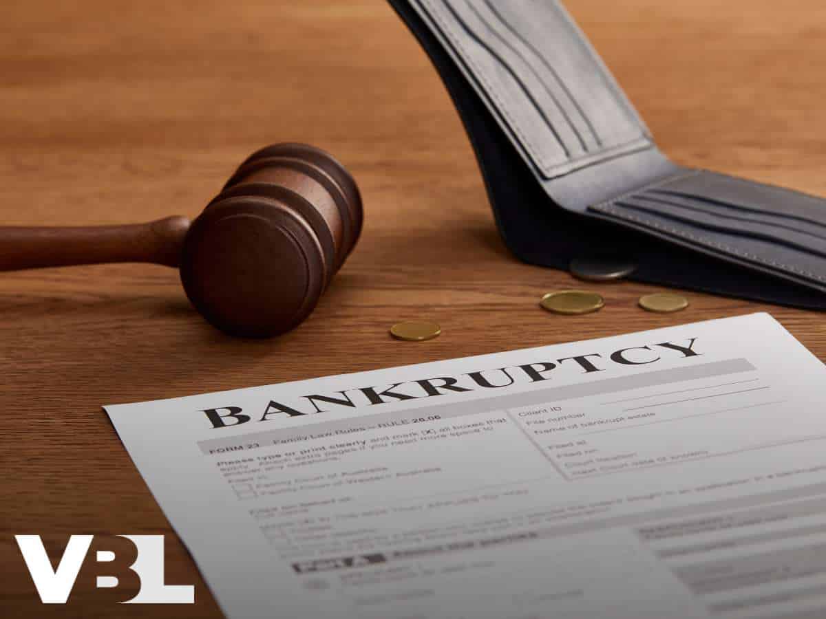 A gavel, coins, and a Bankruptcy form, symbolizing financial legal matters.