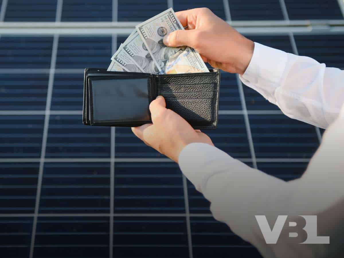 Person handling cash with solar panels in background, illustrating Solar Panels And Bankruptcy In Las Vegas